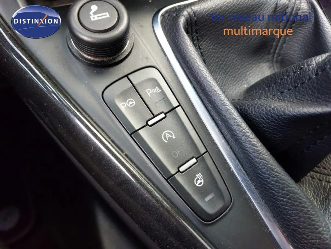 Gros plan sur la console centrale noire de la Ford Focus SW 2018, montrant les boutons de commandes et le soufflet de levier de vitesse en cuir.