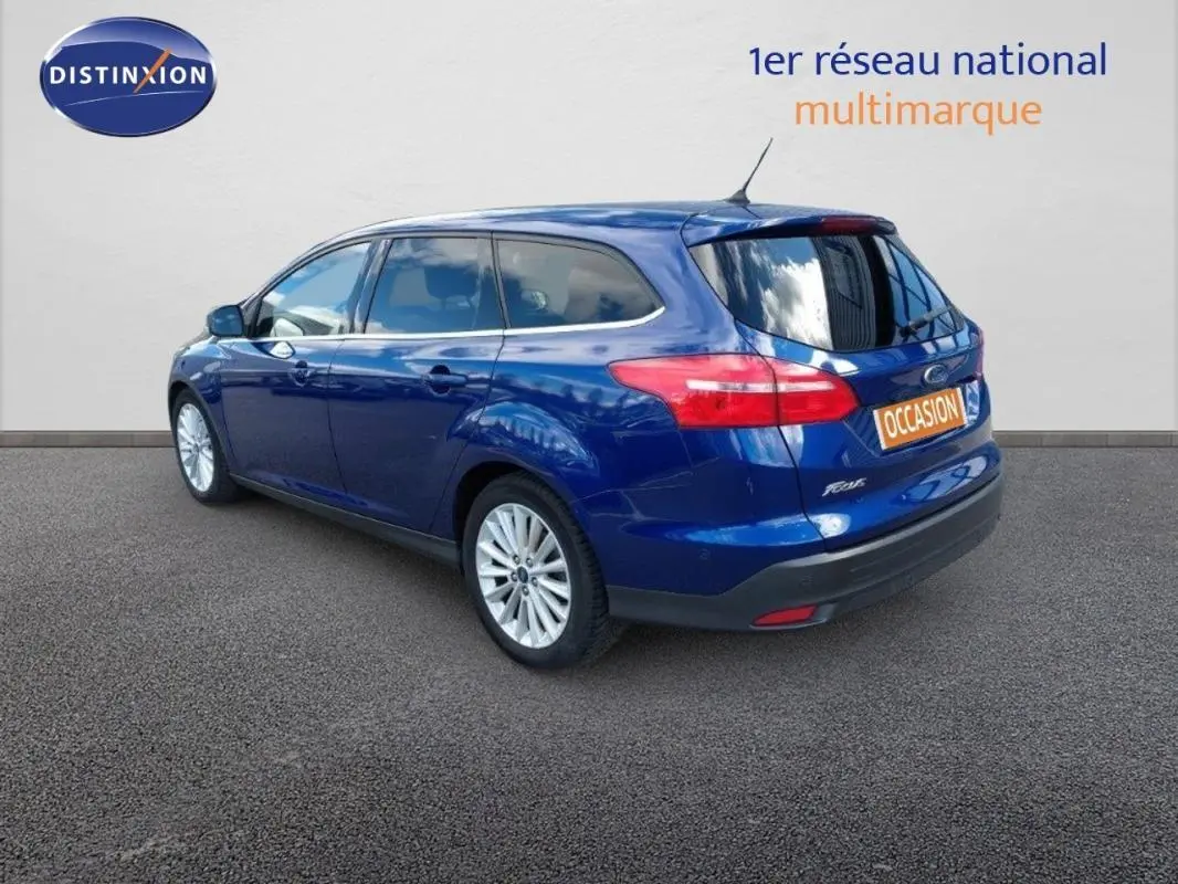 Ford Focus SW bleu foncé vue 3/4 arrière droit avec vitres surteintées et jantes alliage 17 pouces.