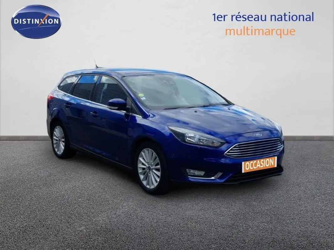 Ford Focus SW bleu foncé vue 3/4 avant droit, jantes alliage 17 pouces et vitres surteintées visibles.