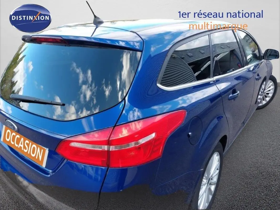 Vue 3/4 arrière droite d'une Ford Focus SW bleu foncé avec vitres surteintées et jantes alliage 17 pouces.