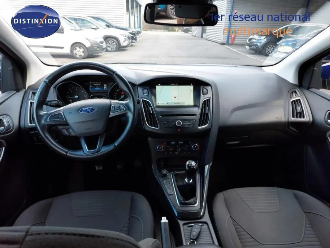 Vue intérieure avant de la Ford Focus SW 2018, tableau de bord noir avec écran tactile et volant multifonction.