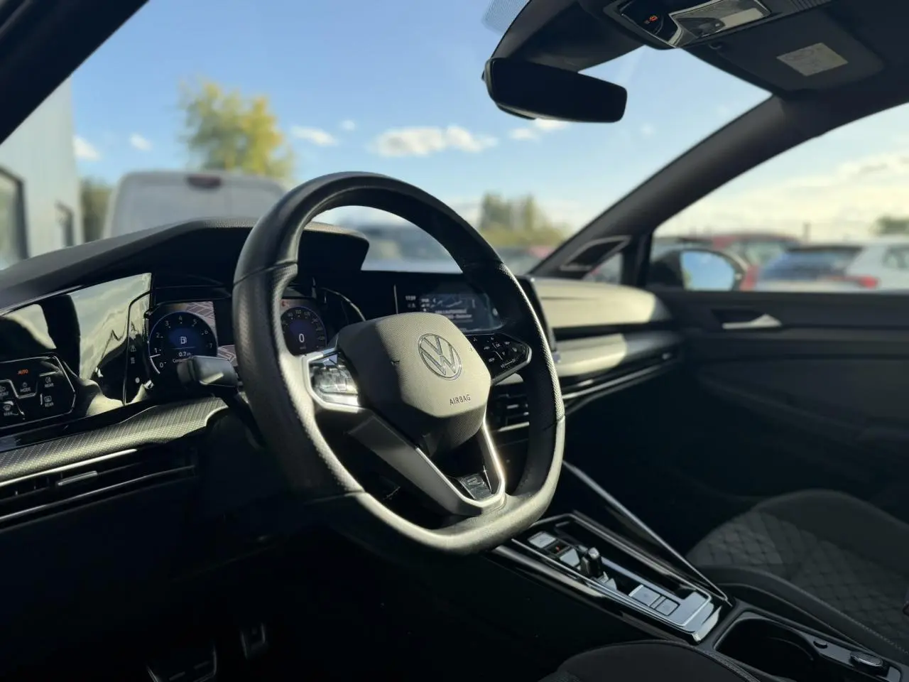Vue intérieure côté conducteur de la Volkswagen Golf 8 R-Line 2024, avec volant cuir multifonction et tableau de bord digital.