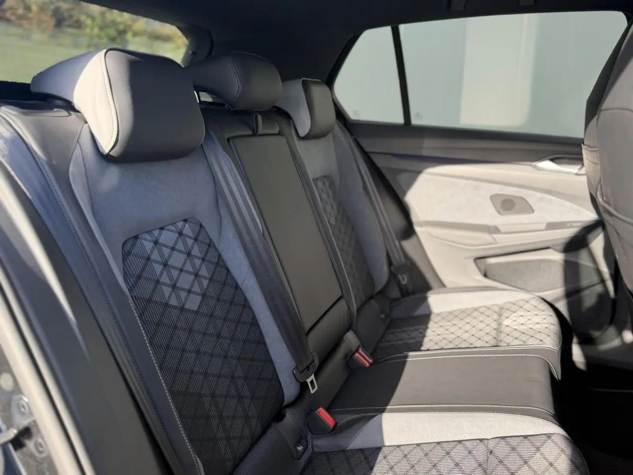 Vue intérieure des sièges arrière en tissu et ArtVelours gris avec motifs losanges dans une Volkswagen Golf 8 R-Line 2024.