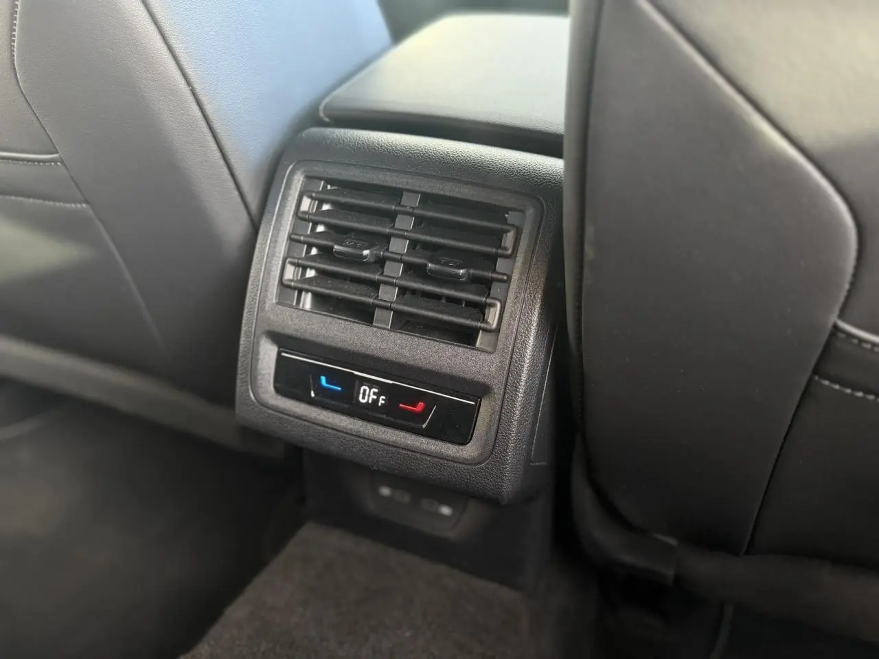 Détail de la console arrière noire avec diffuseurs d'air et commandes de chauffage des sièges dans une Volkswagen Golf 8 R-Line.