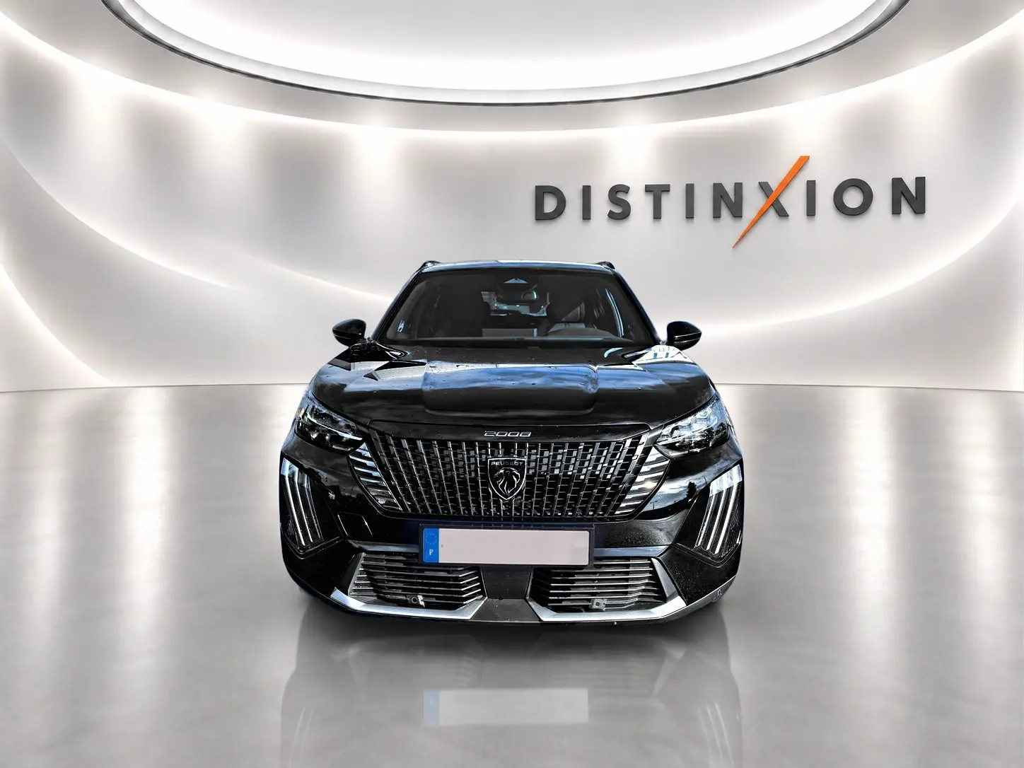 Vue frontale d’un Peugeot 2008 noir brillant avec calandre imposante et logo lion au centre, dans un showroom lumineux.