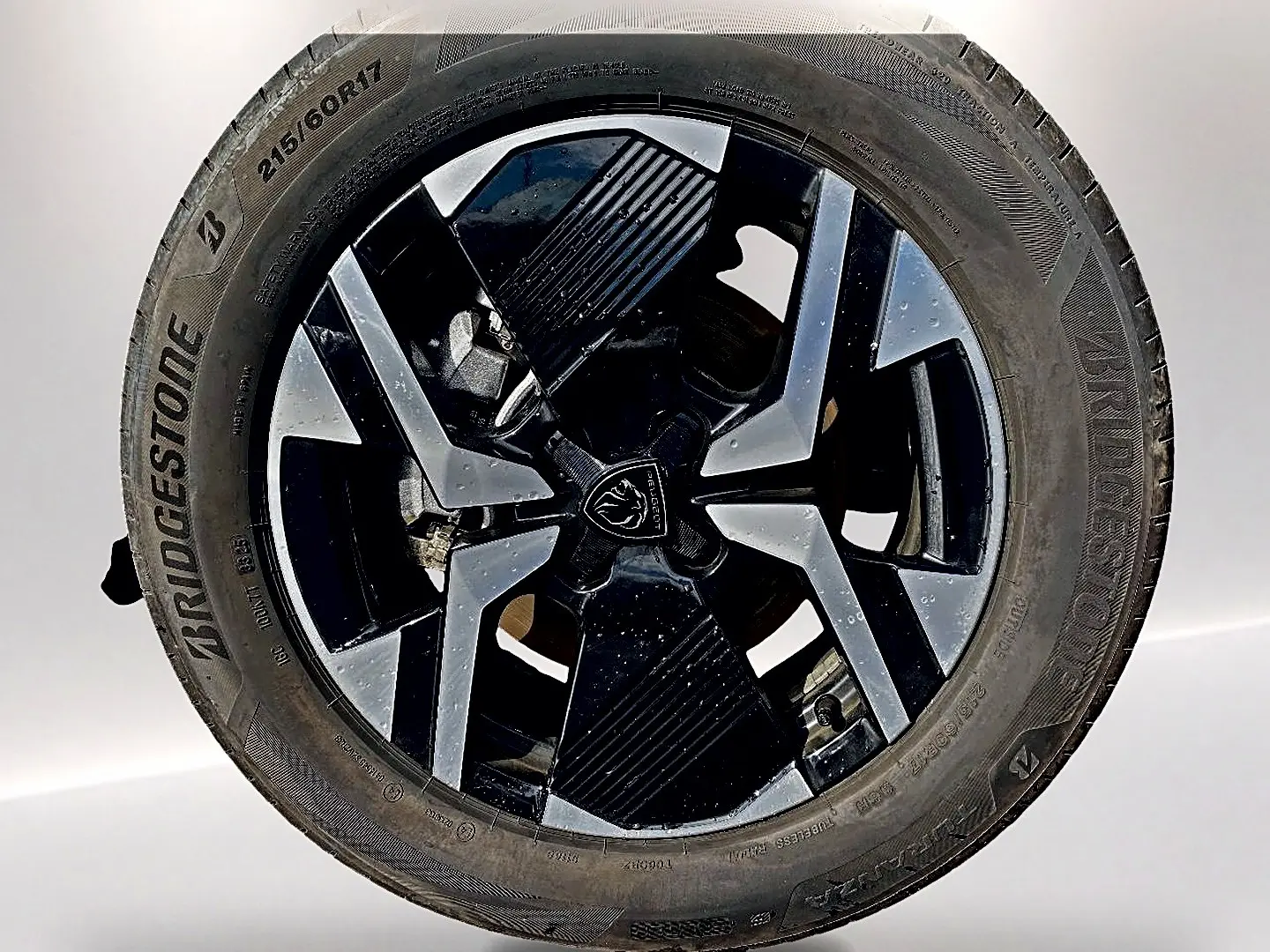 Gros plan sur la jante alu noire et argentée de la Peugeot 2008 1.2 hybrid 145 GT e-DCS6 avec pneu Bridgestone.