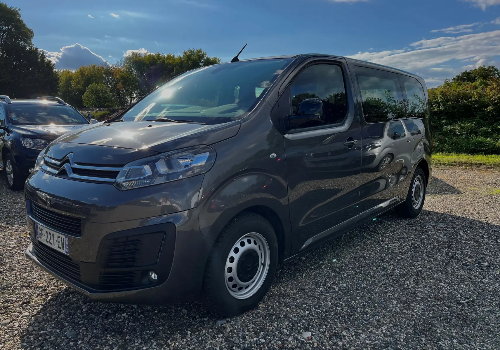 Vue 3/4 avant droite d'un Citroën Jumpy Spacetourer gris foncé 2022 avec jantes acier et 9 places.