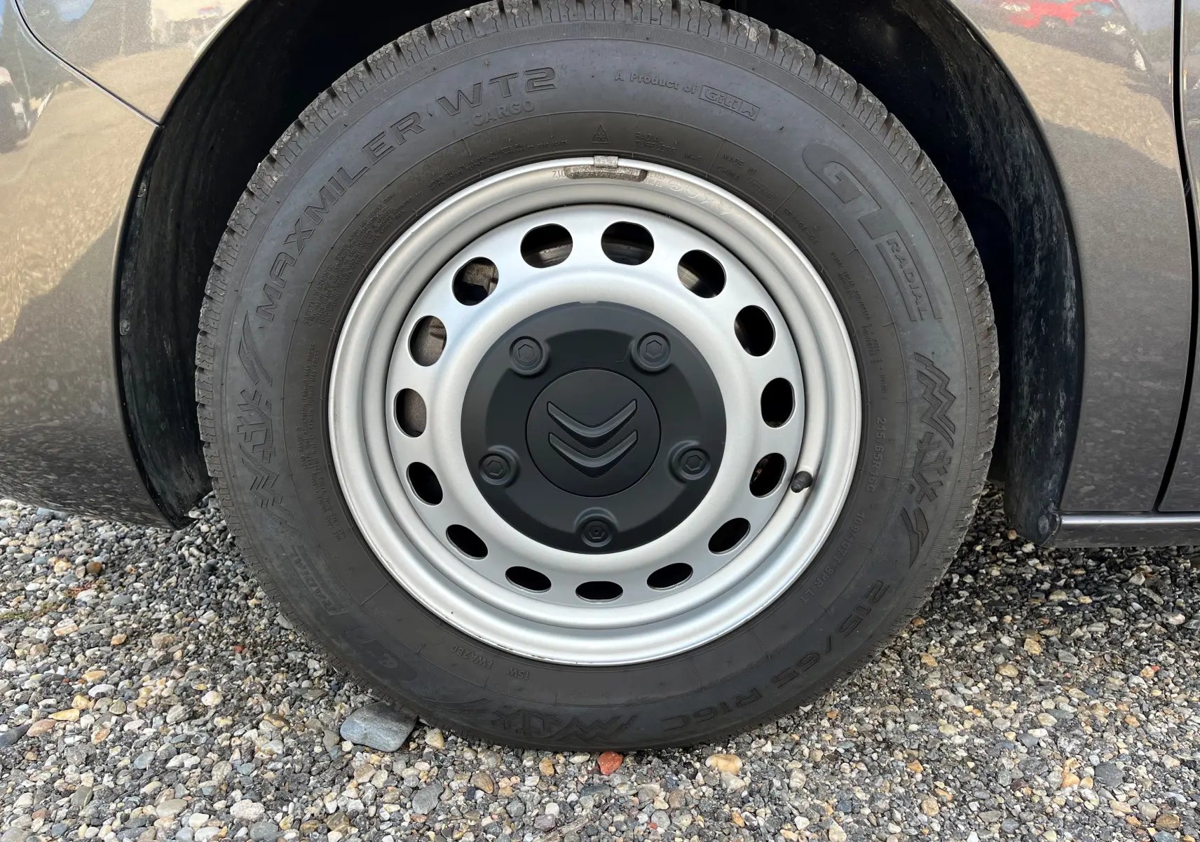 Gros plan sur la roue avant droite d'un Citroën Spacetourer gris 2022 avec jante acier et logo Citroën au centre.