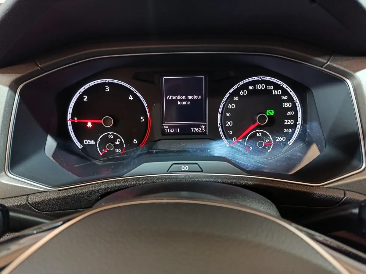 Vue rapprochée du tableau de bord digital du Volkswagen T-Roc 2021, affichant le compteur et un message moteur.