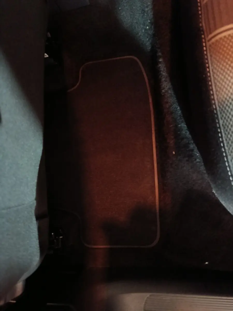 Détail du tapis de sol noir côté passager arrière du Volkswagen T-Roc gris foncé, intérieur sombre.