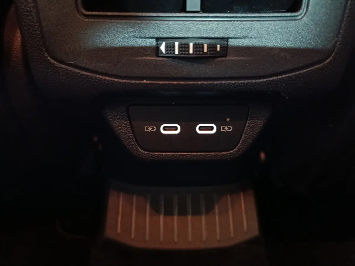 Gros plan sur les deux ports USB-C lumineux situés à l'arrière de la console centrale du Volkswagen T-Roc gris foncé.