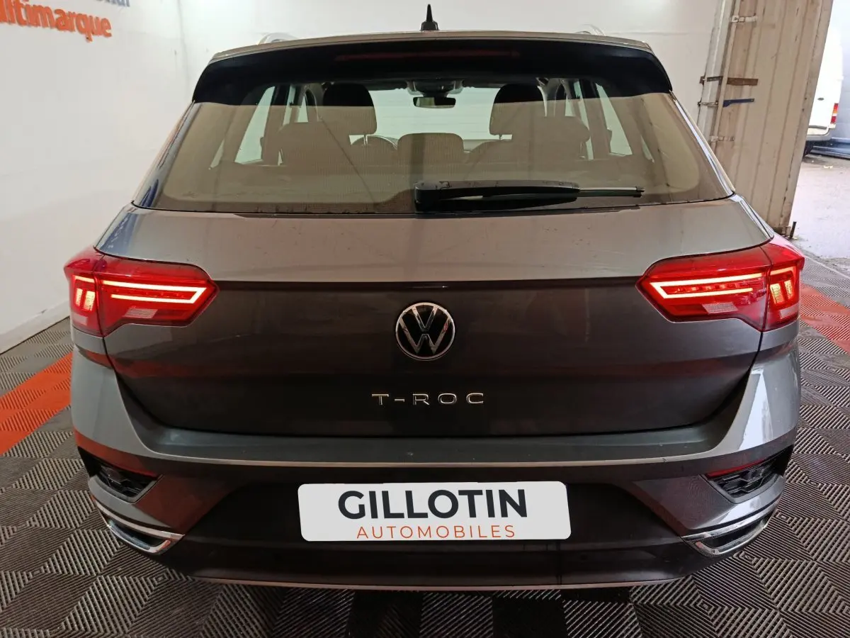 Vue arrière d’un Volkswagen T-Roc gris foncé avec feux LED allumés dans un garage.