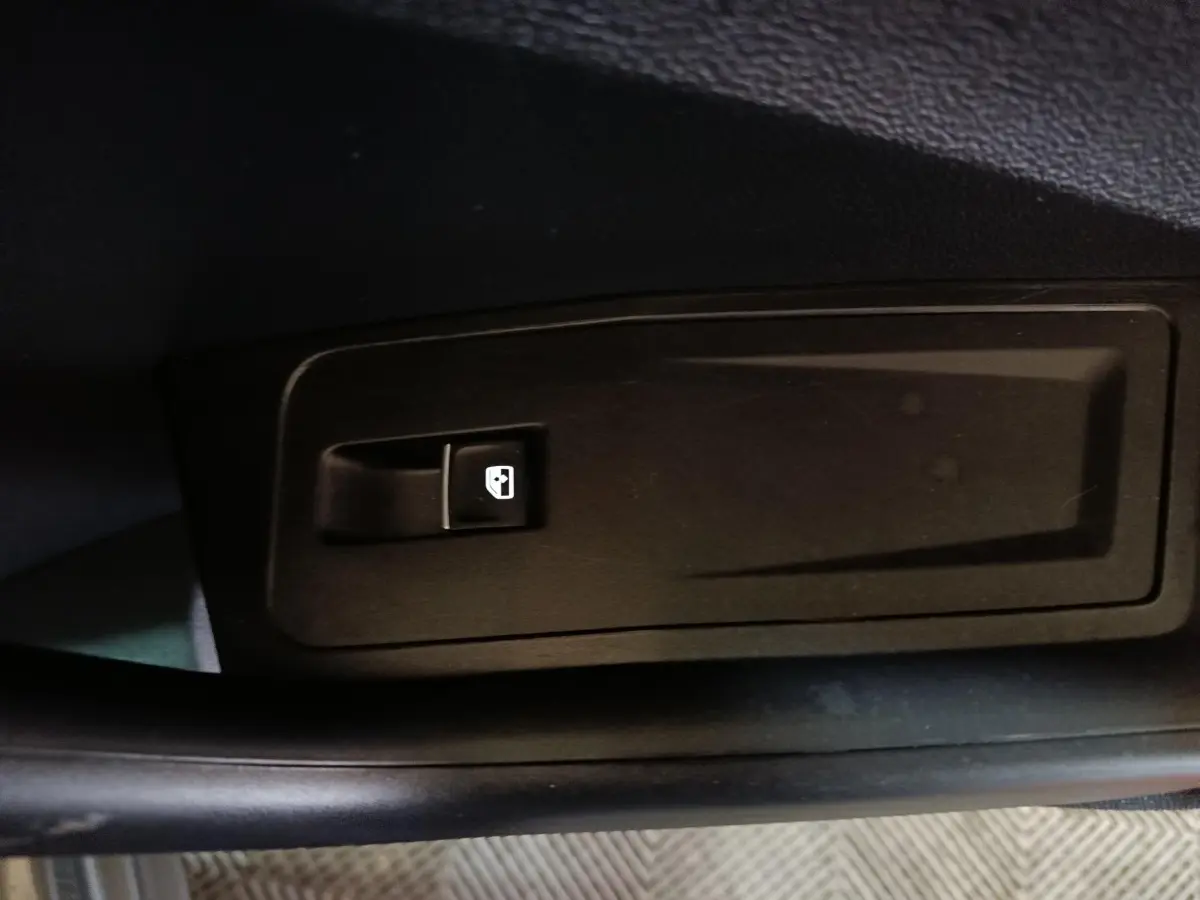 Bouton de commande de lève-vitre électrique sur la porte intérieure côté conducteur du Volkswagen T-Roc gris foncé.