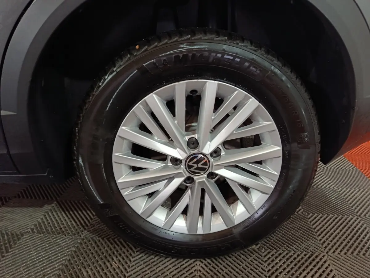 Gros plan sur la roue avant droite du Volkswagen T-Roc gris foncé, mettant en valeur la jante alliage et le pneu Michelin.