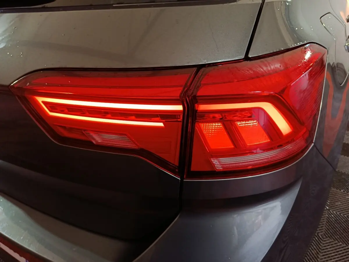 Gros plan sur le feu arrière droit rouge du Volkswagen T-Roc gris foncé, mettant en valeur son design LED moderne.
