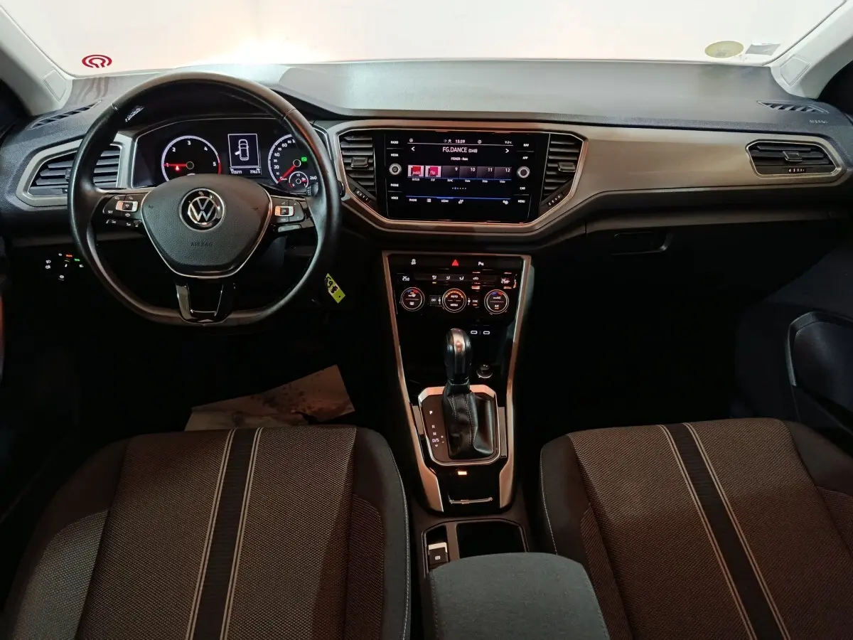 Vue intérieure avant du tableau de bord et volant cuir noir du Volkswagen T-Roc 2.0 TDI gris foncé de 2021.