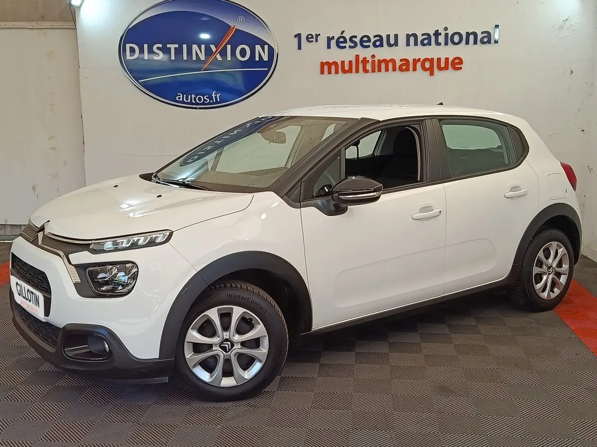 Citroën C3 blanche vue de profil droit en intérieur, avec jantes alliage et détails noirs contrastants.