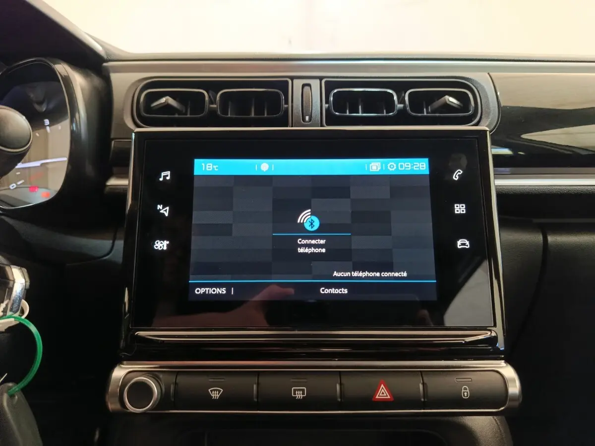Vue rapprochée de l’écran tactile central et des commandes de la planche de bord d’une Citroën C3 blanche 2020.