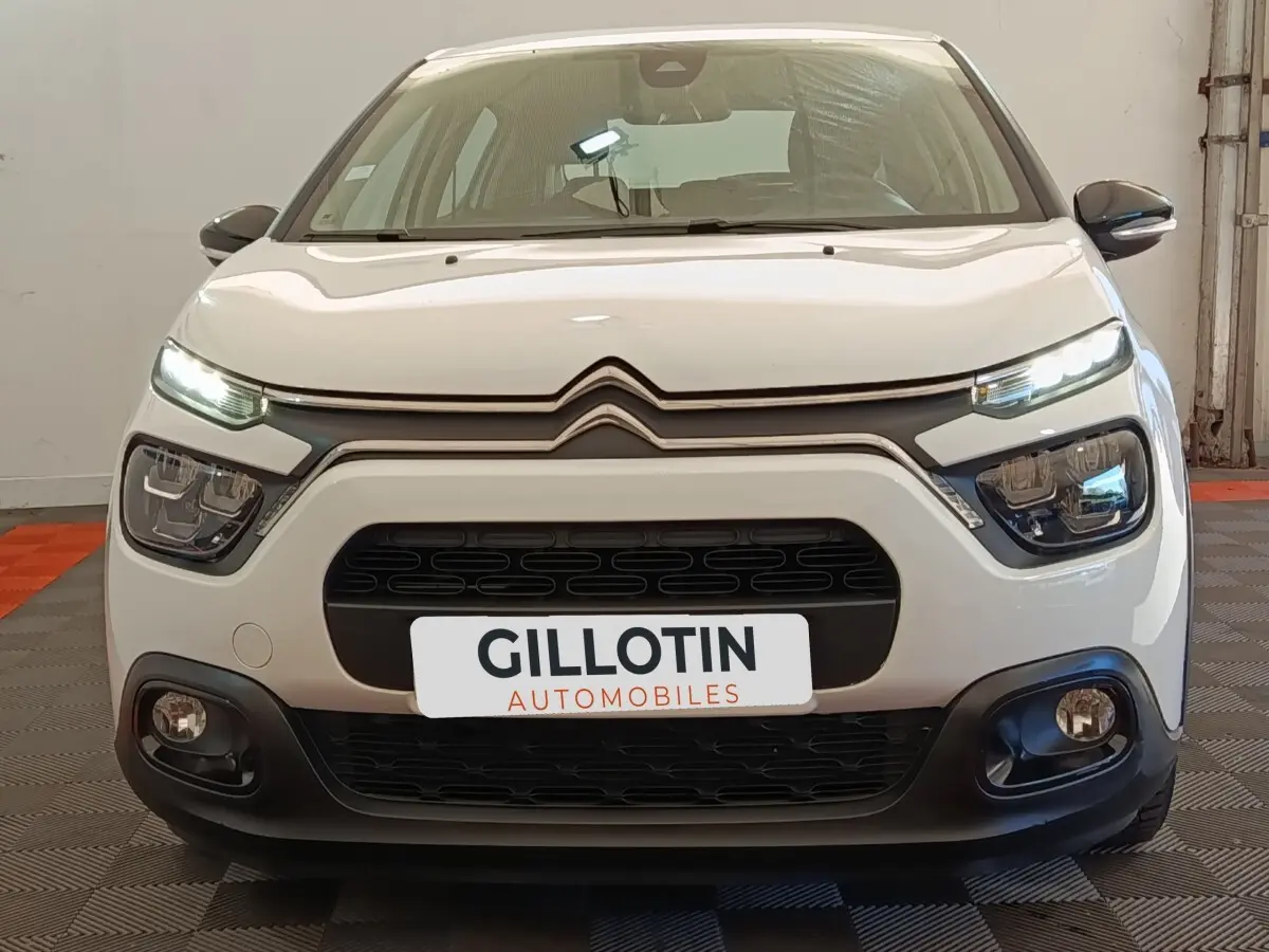 Vue frontale d'une Citroën C3 blanche 2020 avec feux LED allumés et calandre noire distinctive.