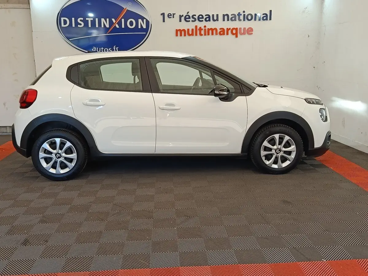 Citroën C3 blanche vue de profil côté gauche, avec jantes alliage et rétroviseurs noirs brillants.