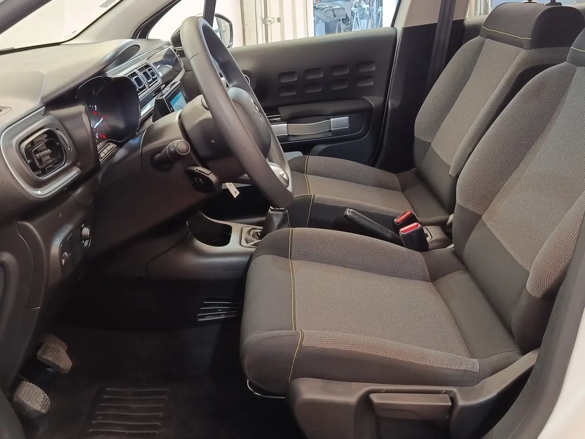 Intérieur avant droit de Citroën C3 blanc 2020, sièges tissu gris et tableau de bord avec écran tactile.