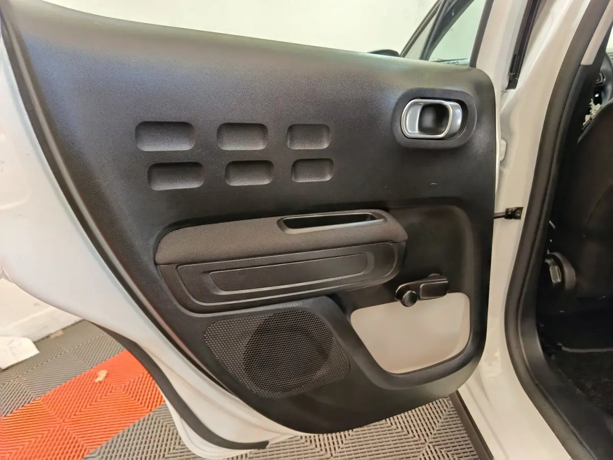 Vue intérieure de la porte arrière droite noire et blanche d'une Citroën C3 blanche de 2020.