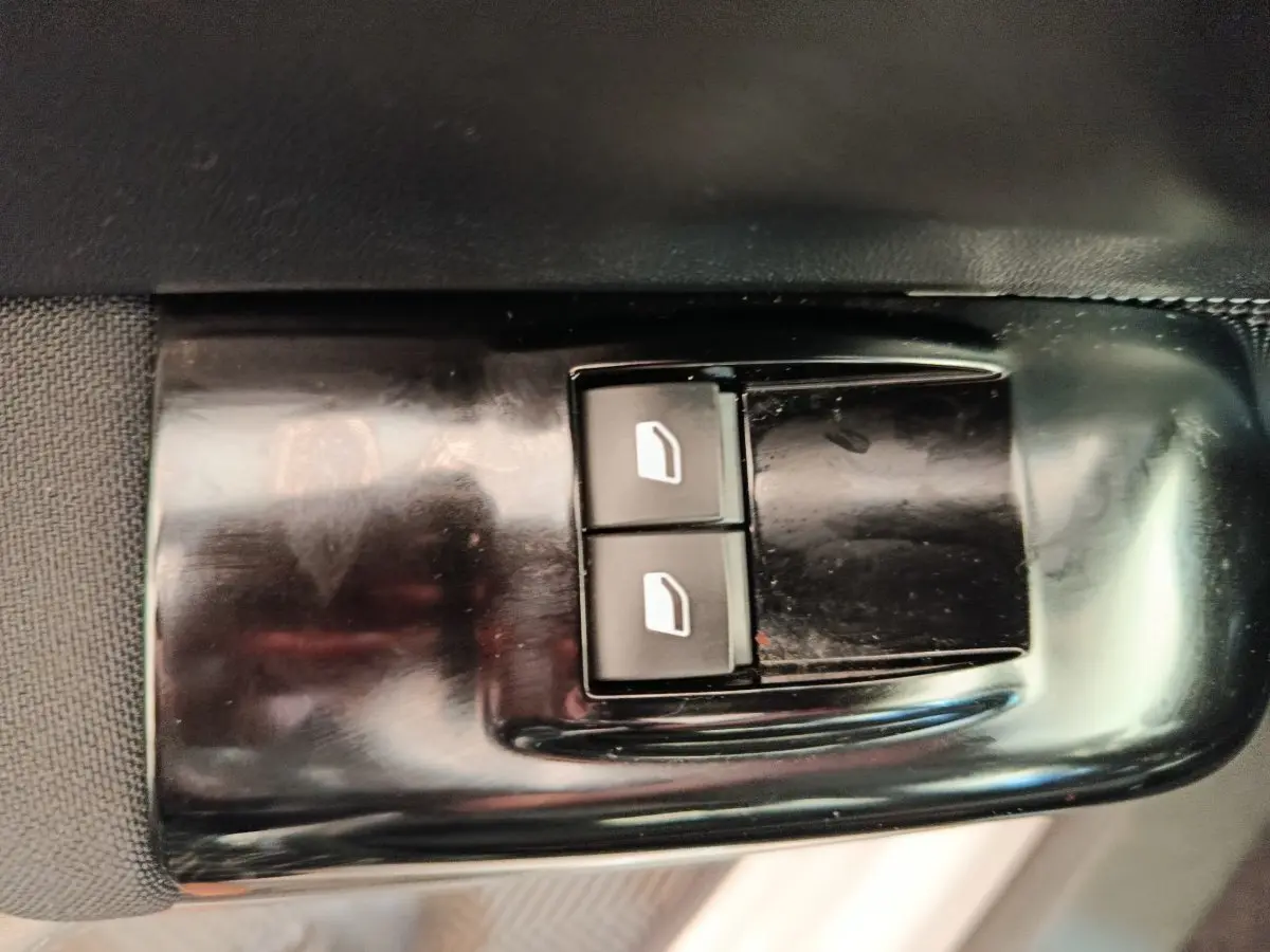 Gros plan sur les commandes des vitres électriques côté conducteur d'une Citroën C3 blanche, version 2020.