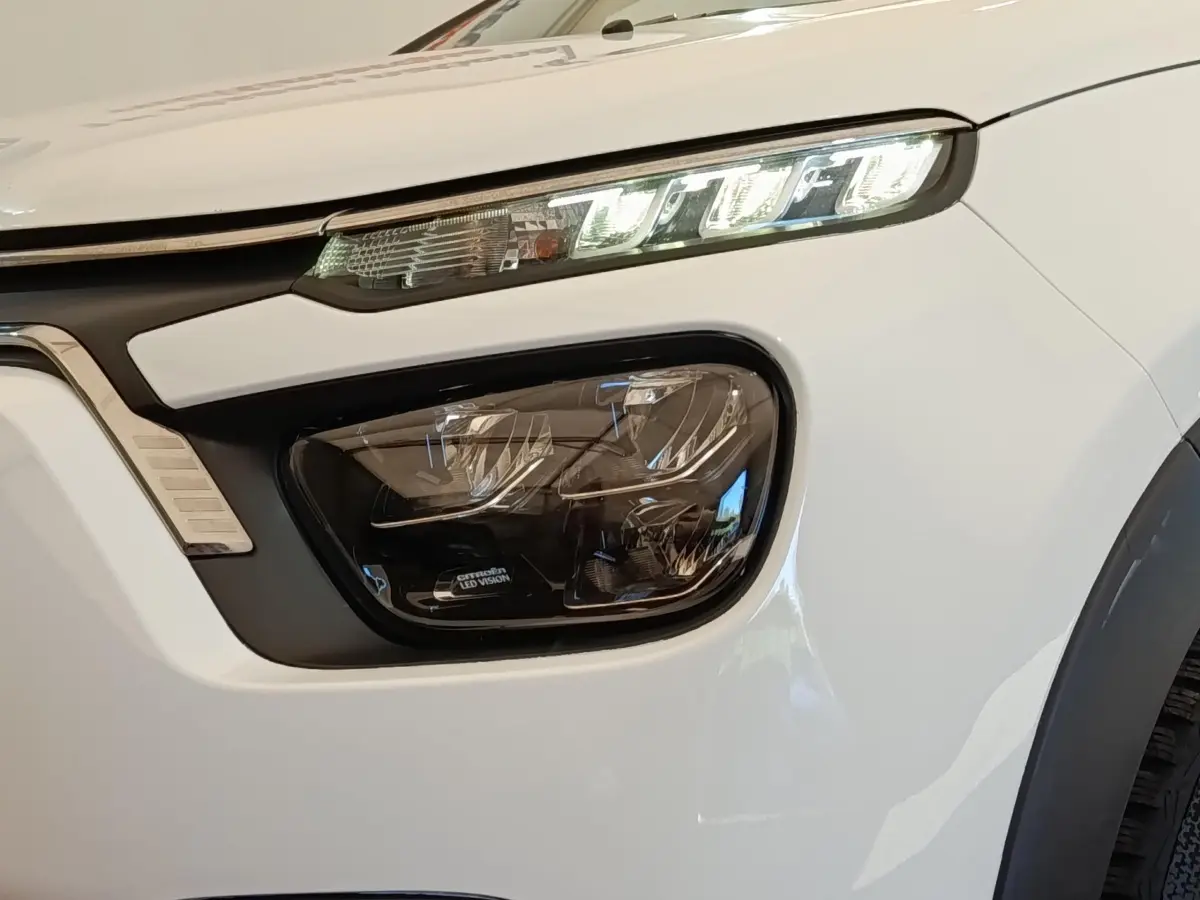 Gros plan sur le phare avant droit blanc de la Citroën C3 2020 avec éclairage LED distinctif et signature lumineuse.