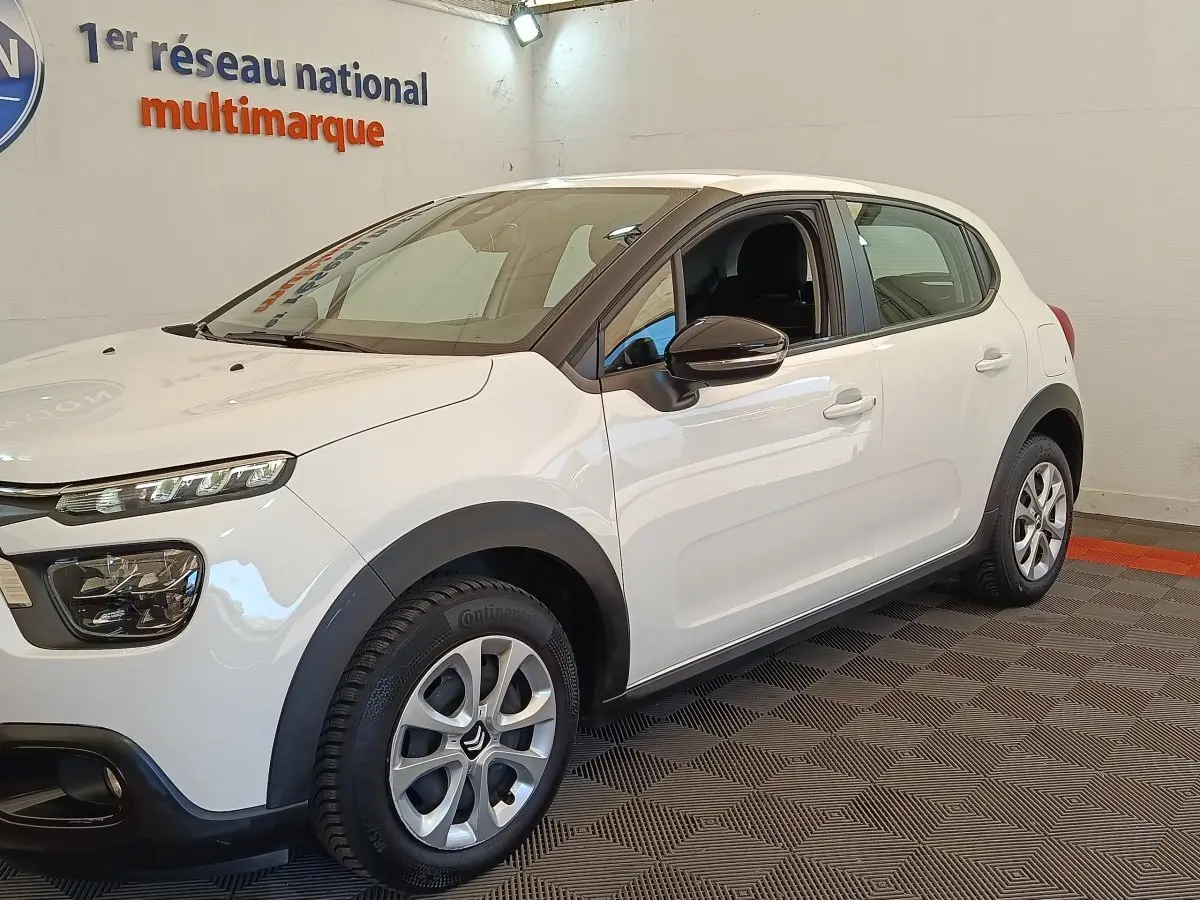Vue 3/4 avant droite d'une Citroën C3 blanche 2020 avec jantes alliage et rétroviseurs noirs.
