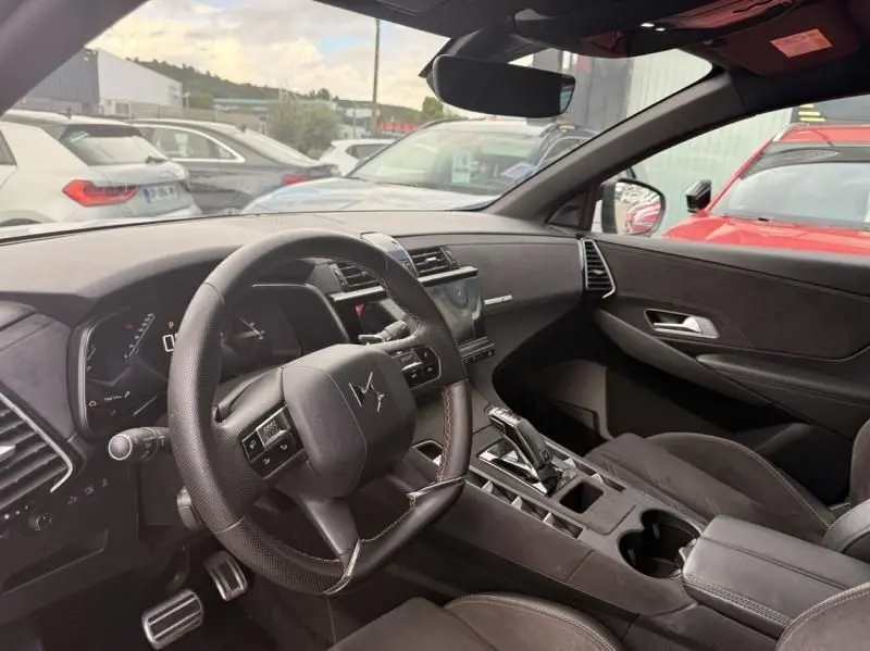 Vue intérieure côté conducteur du DS7 Crossback blanc 2019, mettant en valeur le tableau de bord et la console centrale moderne.