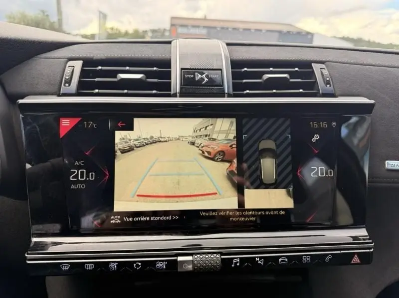 Vue intérieure du tableau de bord du DS7 Crossback blanc 2019, écran multimédia affichant la caméra de recul et les réglages climatiques.