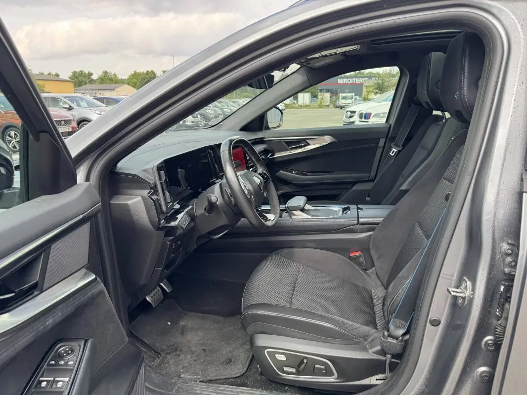 Intérieur côté conducteur du Renault Austral gris 2023, avec sièges sport, volant multifonctions et écran tactile visible.