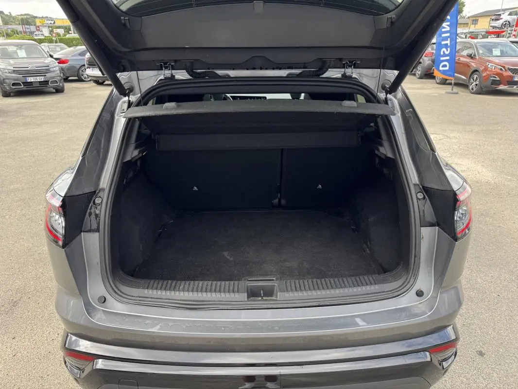 Coffre ouvert vu de l'arrière d'un Renault Austral gris 2023, avec cache-bagages et hayon relevé.
