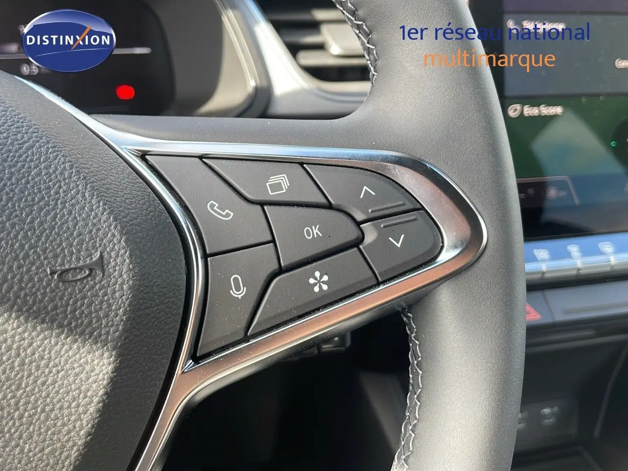 Gros plan sur les commandes multifonctions à droite du volant du Renault Captur 2025, finition noire avec surpiqûres grises.