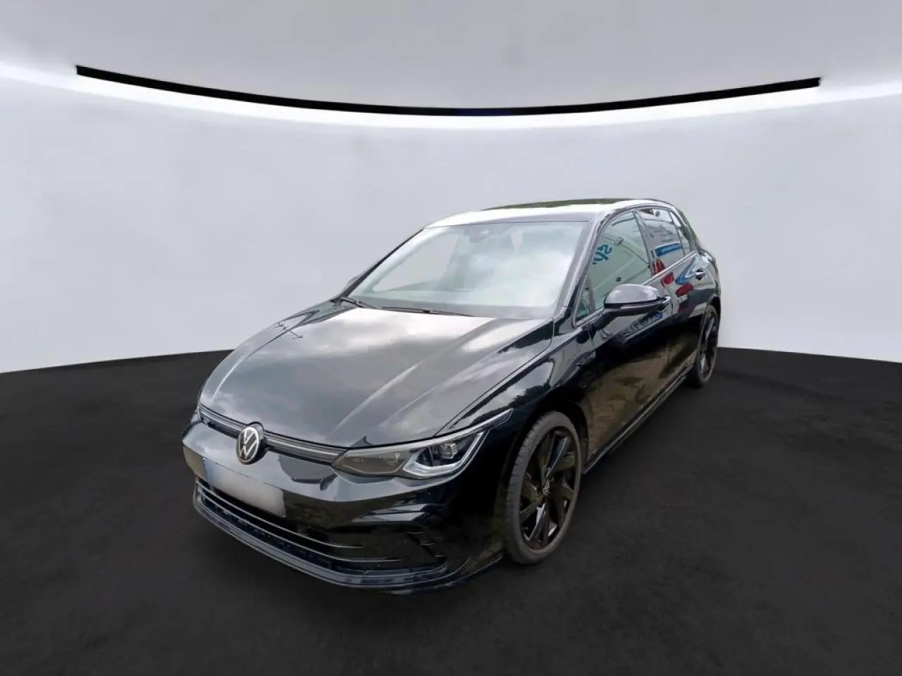 Volkswagen Golf 8 R-Line noire vue 3/4 avant droit avec jantes noires et calandre laquée.