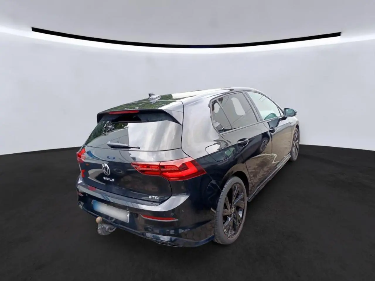 Volkswagen Golf 8 noir vue 3/4 arrière droit avec attelage escamotable et jantes noires 18 pouces.