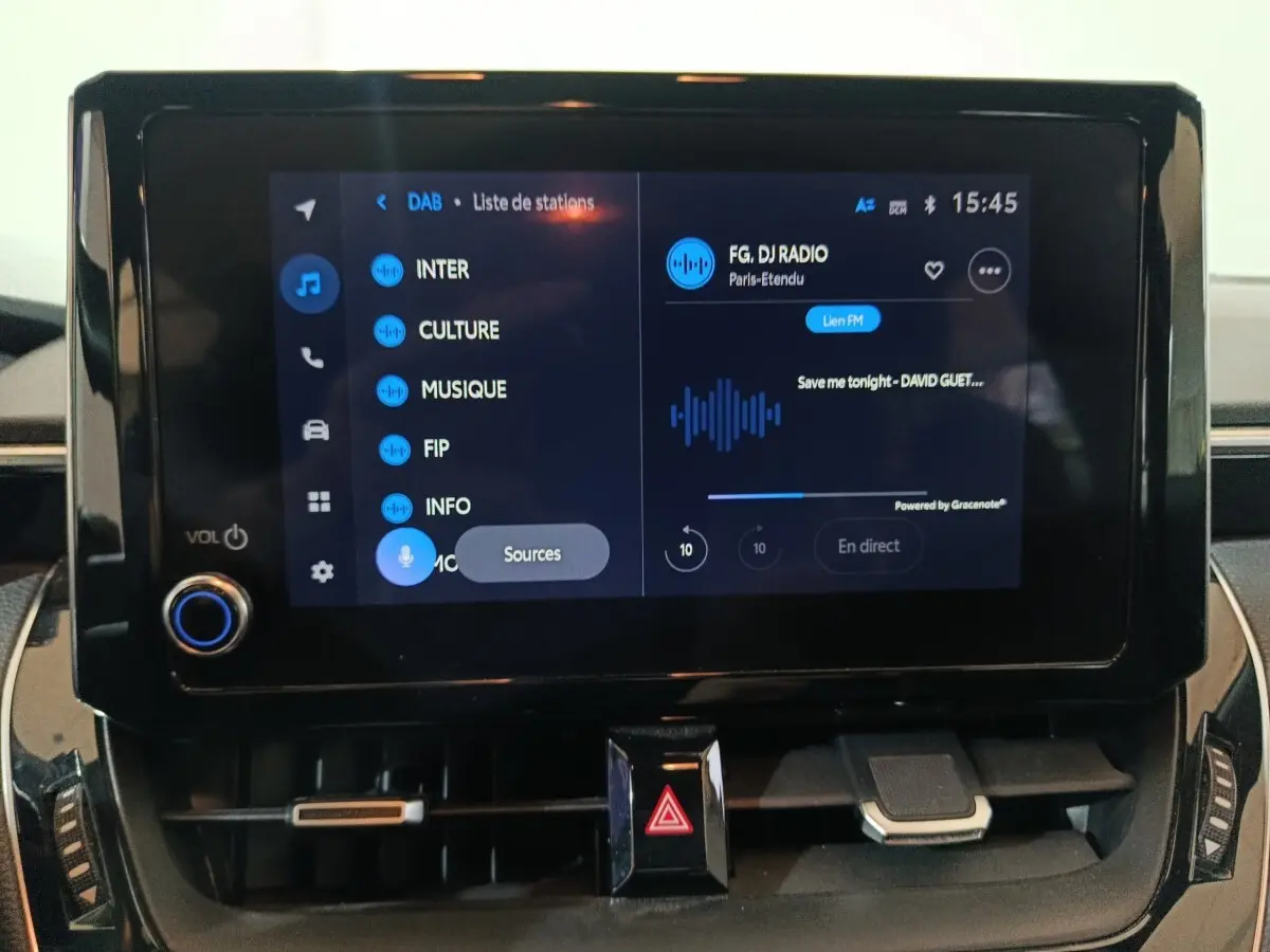 Écran tactile central de la Toyota Corolla hybride 2022 affichant une interface radio numérique en intérieur.
