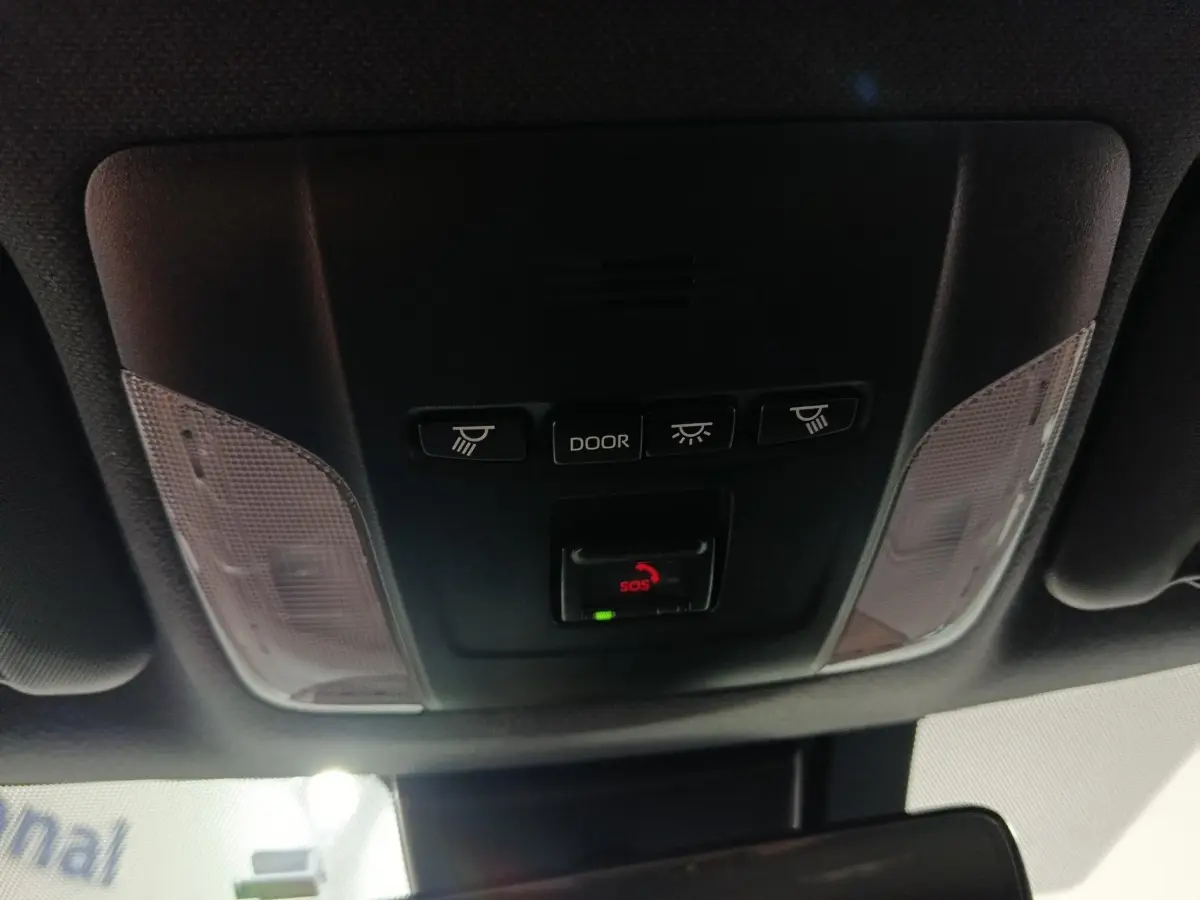 Vue en gros plan du plafonnier intérieur noir de la Toyota Corolla hybride 2022 avec boutons d'éclairage et alerte SOS.