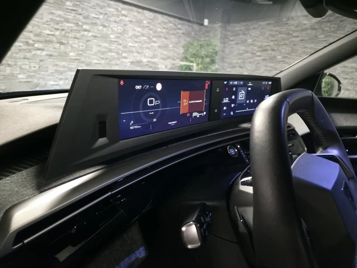 Vue intérieure du tableau de bord et volant noir de la Peugeot 5008 2025 avec double écran HD panoramique.