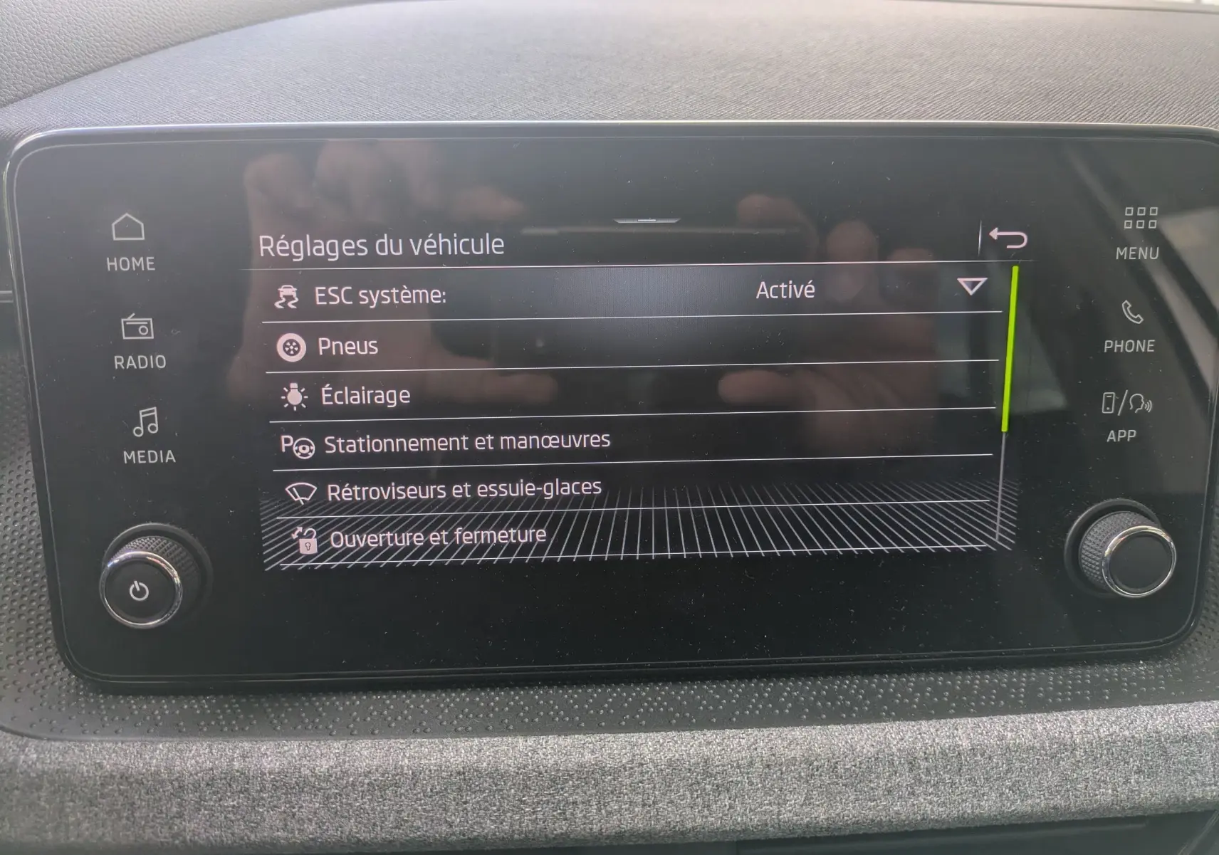 Écran tactile central de la Skoda Scala gris Reflex affichant les réglages du véhicule en mode menu.