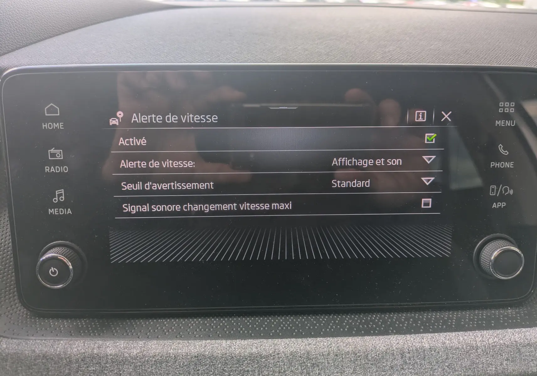 Écran tactile central du Skoda Scala gris Reflex 2025 affichant le menu des alertes de vitesse avec options activées.