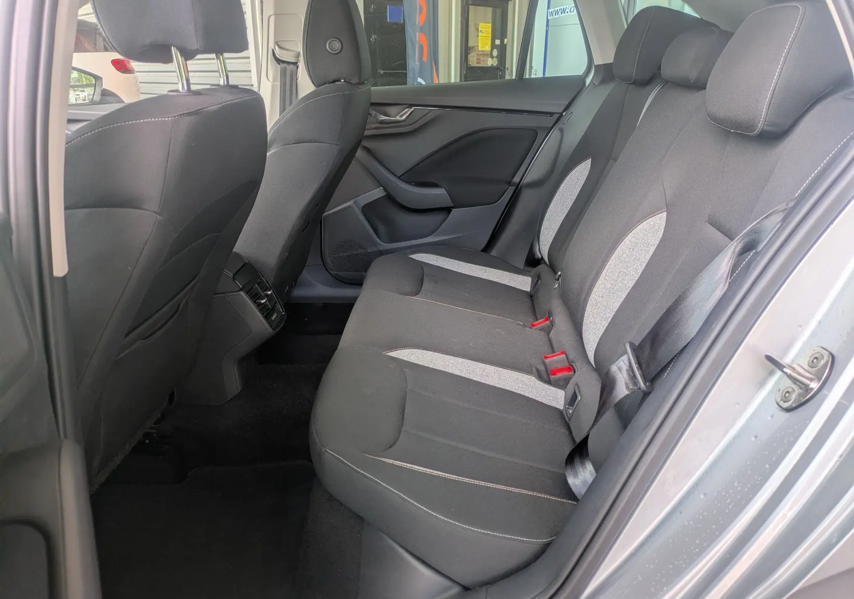Vue intérieure côté droit des sièges arrière en tissu noir et gris d'une Skoda Scala gris reflex 2025.