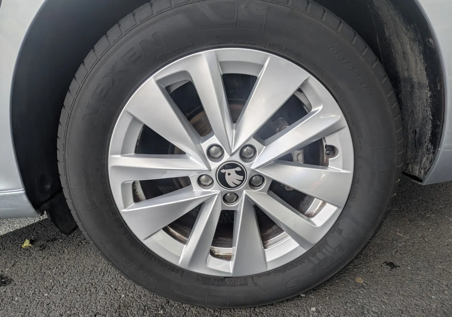 Gros plan sur la roue avant gauche gris reflex d'une Skoda Scala 2025 avec jante alliage et logo Skoda au centre.