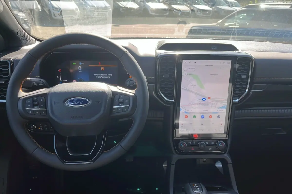 Vue intérieure du tableau de bord du Ford Ranger 2026 avec volant cuir multifonctions et grand écran tactile vertical.