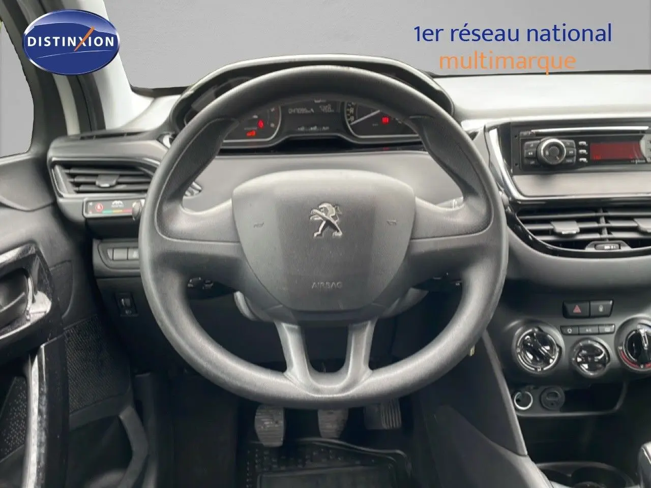 Vue intérieure centrée sur le volant noir de la Peugeot 208 Société 2018, avec tableau de bord et commandes visibles.