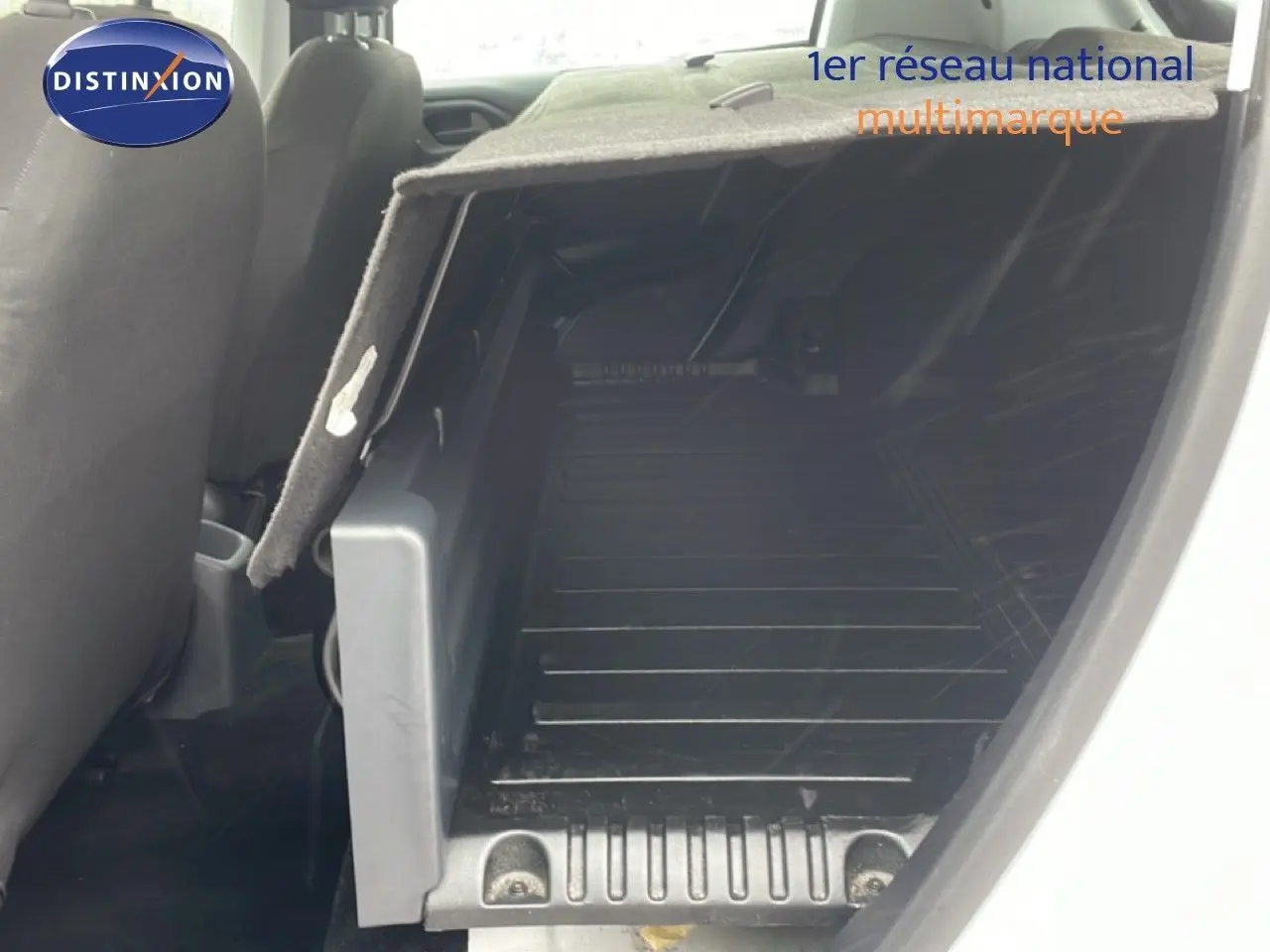 Vue intérieure côté droit du coffre ouvert d'une Peugeot 208 Société blanche, montrant l'espace de chargement vide.
