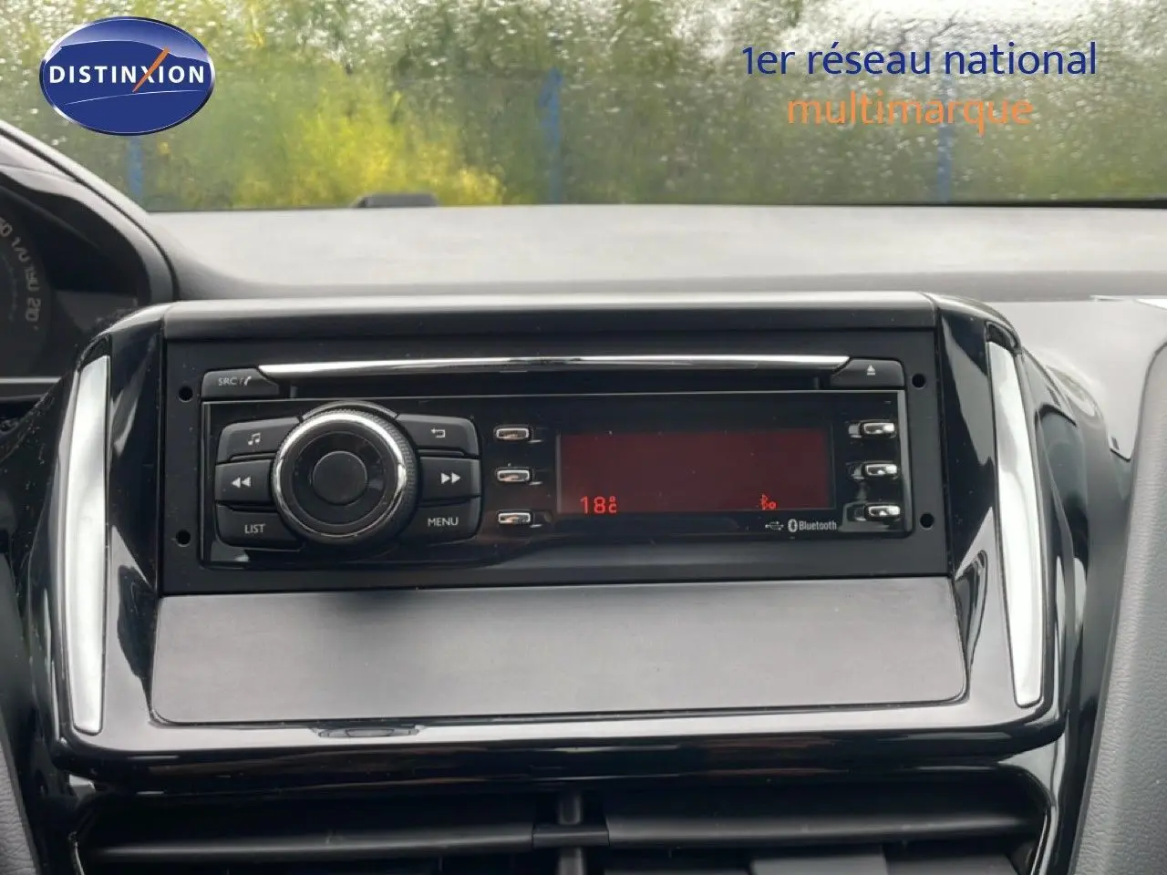 Vue rapprochée du tableau de bord de la Peugeot 208 Société 1.6 HDI 75ch Premium, avec système audio intégré.