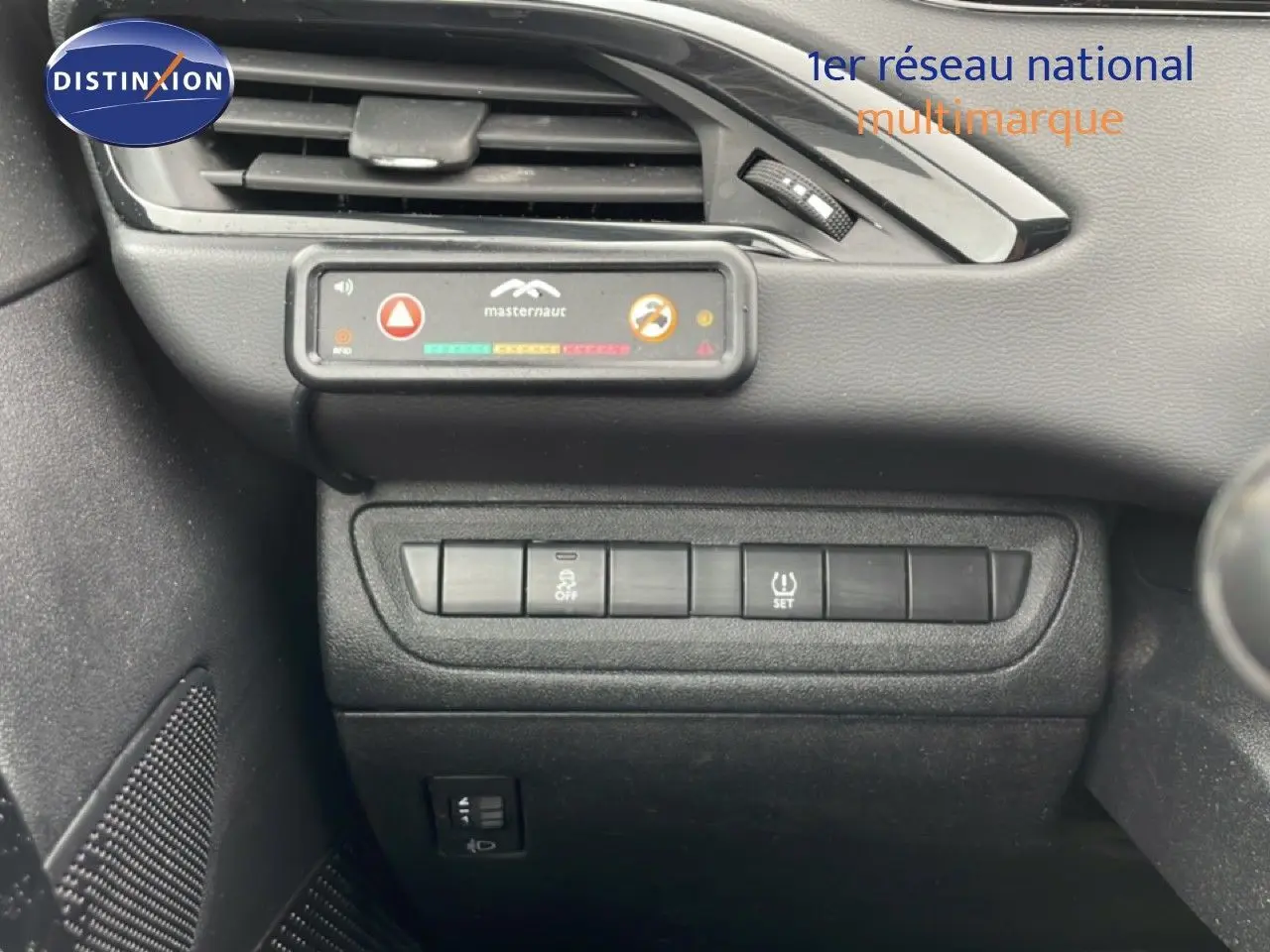 Vue rapprochée du tableau de bord noir de la Peugeot 208 Société 2018, montrant les boutons de commande et une alerte Masternaut.