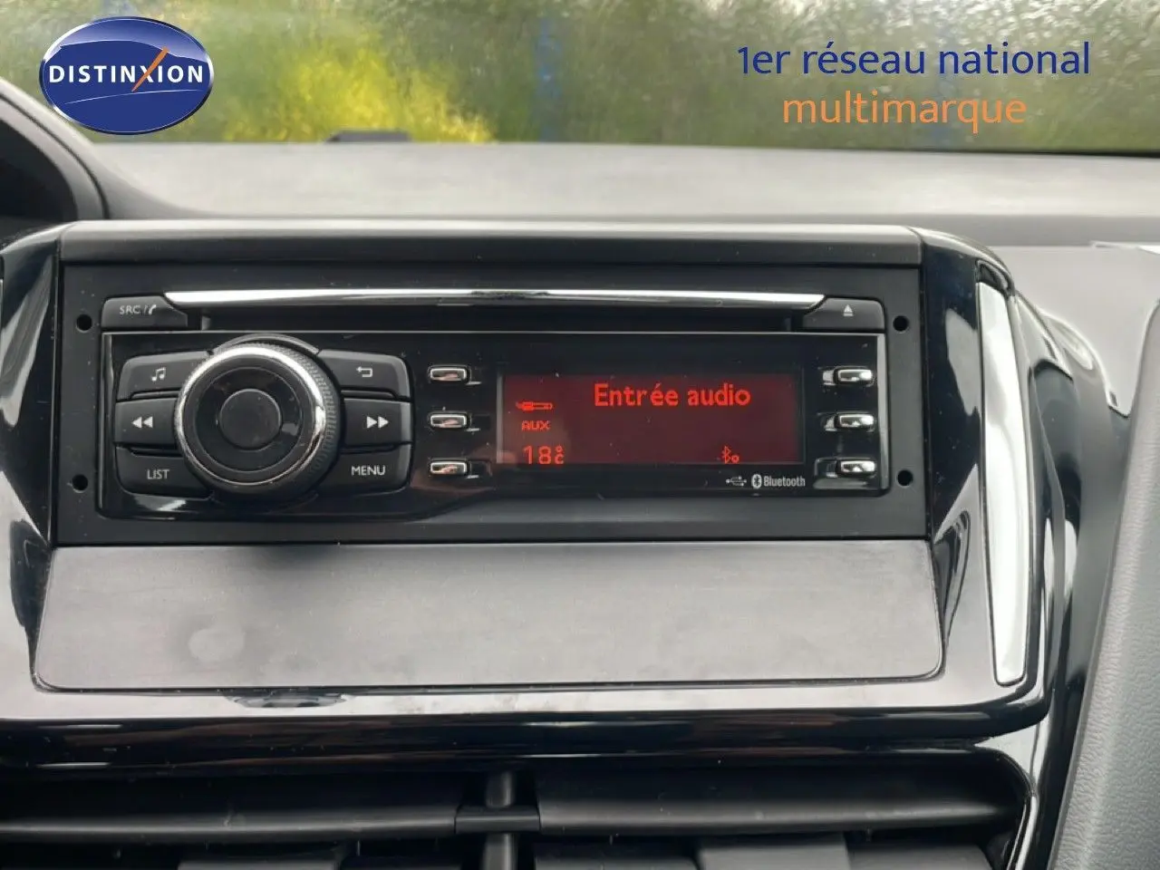 Vue rapprochée de la console centrale noire du Peugeot 208 Société 2018 avec écran audio affichant "Entrée audio".