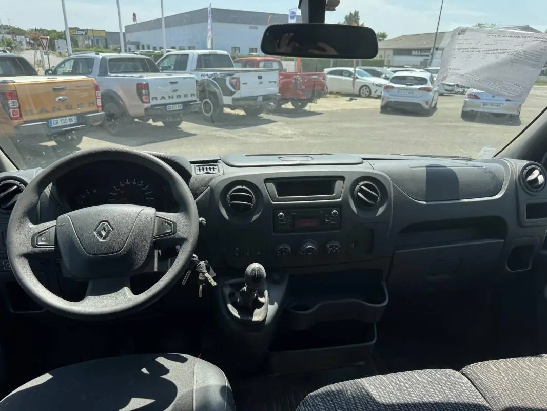 Vue intérieure du poste de conduite du Renault Master blanc 2019, avec volant, tableau de bord et levier de vitesses manuel visibles.